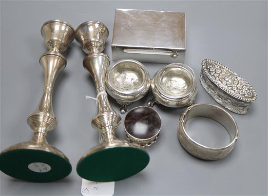 A pair of silver candlesticks, cigarette box, salts, lidded jars and a bracelet.